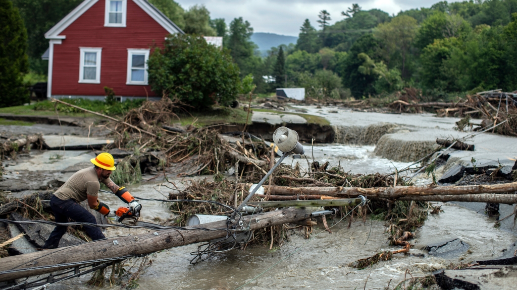 Worker clears tree amid flooding