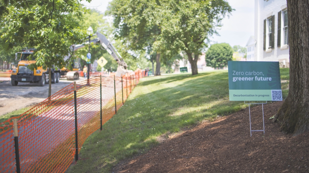 Green sign on lawn in front of white building